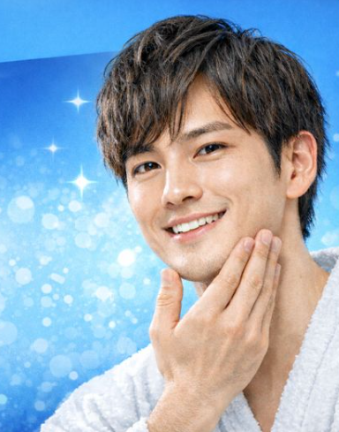 メンズリゼの広告用アイキャッチ画像で、若い男性が清潔感のある白いバスローブを着て、頬に手を添え微笑む姿を青いグラデーション背景の前で撮影した写真